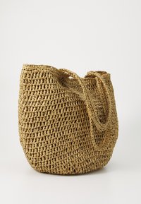 Geweven stro handtas in natuurlijk beige. Rondvorm met twee stevige handgrepen. Textuur oppervlakte met een open bovenkant ontwerp.