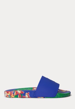 Μπλε σανδάλι με φαρδιά λουράκι, πολύχρωμο τροπικό λουλουδένιο σχέδιο στην επιφάνεια και τη σόλα, εμφανιζόμενο από το πλάι σε λευκό φόντο.