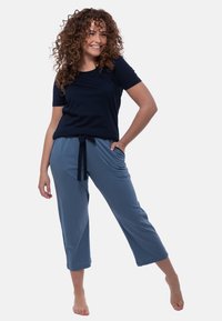 Marinblå kortärmad topp med rund hals som matchas med ljusblå capribyxor med elastisk midja och dragsko. 