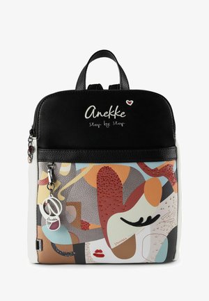 Schwarz-weißer Anekke-Rucksack mit farbenfrohem abstraktem Gesichtsmotiv, roten Strasssteinen und einem herzförmigen Anhänger am Reißverschluss.