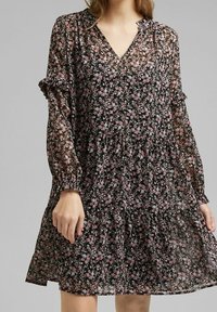 Vestido largo negro de flores con mangas largas y escote en V, decorado con flores rosas y azules, puños con volantes y un diseño de falda en capas. Tejido semitransparente.