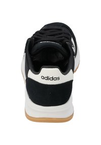 Crno-bijela atletska cipela s glatkim gornjim materijalom, teksturiranim nubuk akcentima, sustavom vezanja i gumiranim potplatom.