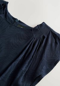 Blusa navy con motivo floreale, in tessuto morbido, maniche corte con pieghe e chiusura a zip discreta sul retro.