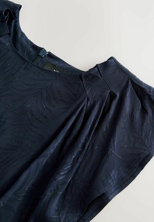 Navybluse med blomsterprint, blødt tekstureret stof, korte ærmer med plisseringer og en diskret lynlås bagpå.
