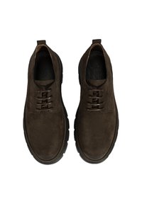 Chaussures en daim marron avec une finition lisse, bout rond et design à lacets. Semelle extérieure en caoutchouc épaisse et design minimaliste sans marquage visible.