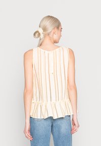 Blusa clara, sem mangas, com riscas verticais, bainha franzida e fecho de botão nas costas. O tecido texturizado acrescenta profundidade.