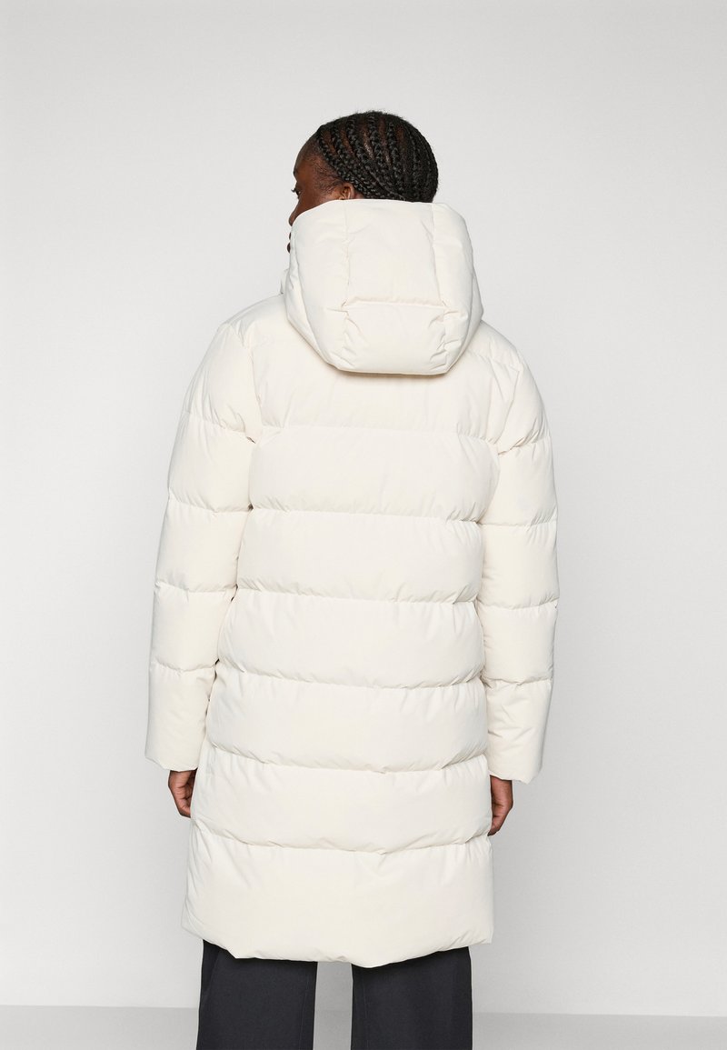 Kurtka puchowa w kolorze ecru, z kapturem i pionowym pikowaniem. Średniej długości, o gładkim wykończeniu i długich rękawach.