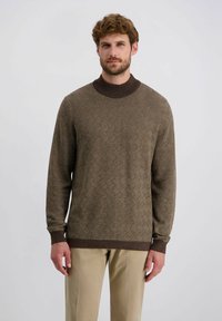 Brauner Pullover mit einem strukturierten Rautenmuster,ribbeligem Rundhals und Bündchen. Kombiniert mit beigen Hosen, lässig gestylt.