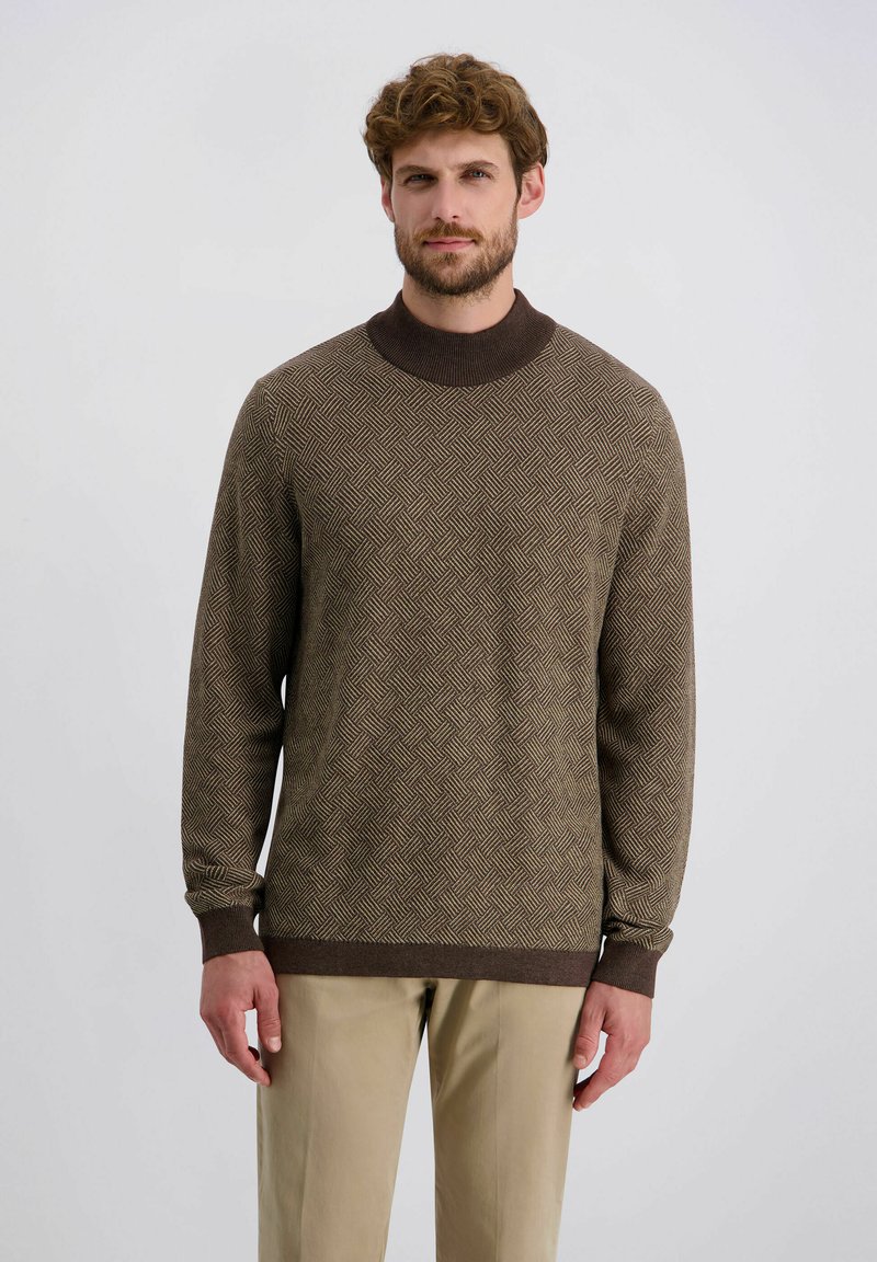 Brauner Pullover mit einem strukturierten Rautenmuster,ribbeligem Rundhals und Bündchen. Kombiniert mit beigen Hosen, lässig gestylt.