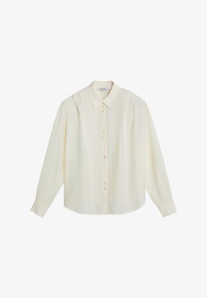 Blusa de manga larga color crema con botones frontales, cuello clásico y sutiles pliegues en el hombro.