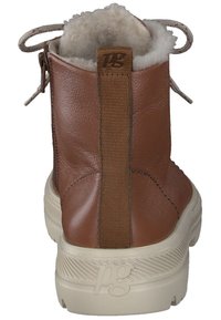 Bottines en cuir marron avec doublure intérieure en peluche, panneaux latéraux élastiques et semelle en caoutchouc beige avec un détail texturé et un marquage.