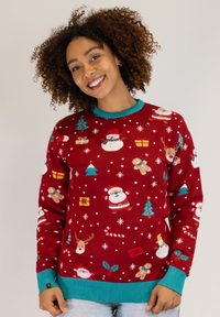Red knitted sweater featuring festive patterns of Santa, trees, gifts, and snowflakes. Turquoise accents at the neckline and cuffs.