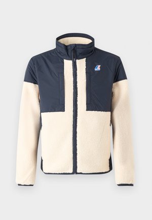Fleece- og nylonjakke med kremfarget kropp og marineblå armer, med høy krage, frontglidelås og logo-lapp på brystet.