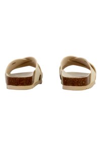 Sandali beige con design a bande incrociate, suola piatta e fondo piedi marrone texturizzato. Realizzati in materiale flessibile, con una finitura liscia.