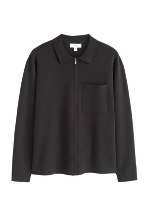 Schwarze langärmelige Jacke mit Reißverschluss, Kragen und Brusttasche, aus weichem Stoff, Größe M, Markenetikett innen am Kragen sichtbar.