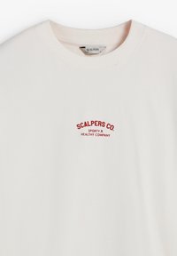 Sudadera de algodón blanca con cuello redondo, puños acanalados y un logotipo bordado en rojo en el pecho que dice "SCALPERS CO. SPORTY HEALTHY COMPANY."