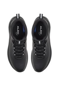 Sneaker nere impermeabili presentano un design elegante, una tomaia testurizzata, lacci bianchi a contrasto e una suola in gomma testurizzata con bordi arrotondati.