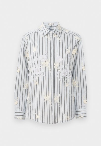 Light blue striped button-up shirt with white floral embroidery, long sleeves, and contrasting black accents on the cuffs and collar.