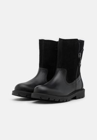 Schwarze Knöchelstiefel mit einer Kombination aus glattem Leder und Wildlederpaneelen. Seitlicher Reißverschluss und robuste Gummisohle für Halt.