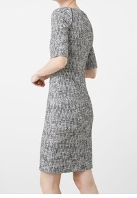 Knit-puku, jolla on tiukka muoto, lyhyet hihat ja kuvioitu kangas mustan, valkoisen ja harmaan sävyissä. Pyöreä kaula-aukko ja polveen ulottuva pituus.