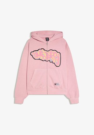 Világos rózsaszín cipzáras kapucnis pulóver elülső zsebekkel és színes graffiti stílusú felirattal a mellkason, kapucnival és bordázott mandzsettákkal.
