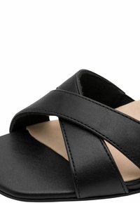 Sandalia tipo slide de cuero negro con tiras cruzadas, textura suave y suela plana con forro interior natural.