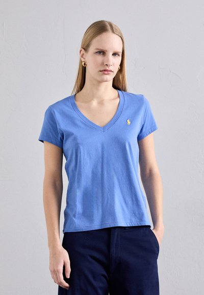 T-shirt à col en V à manches courtes en coton bleu clair, avec un petit logo jaune sur la poitrine et une coupe décontractée.