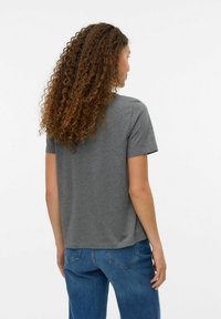 Tricou gri cu mânecă scurtă, în croi lejer, cu gât rotund și textură netedă. Purtați cu blugi albaștri, arătând din spate.