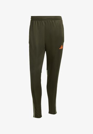 Zelené sportovní kalhoty vyrobené z hladké, lehké tkaniny, s elastickým pasem, oranžovým logem a bílými bočními akcenty.