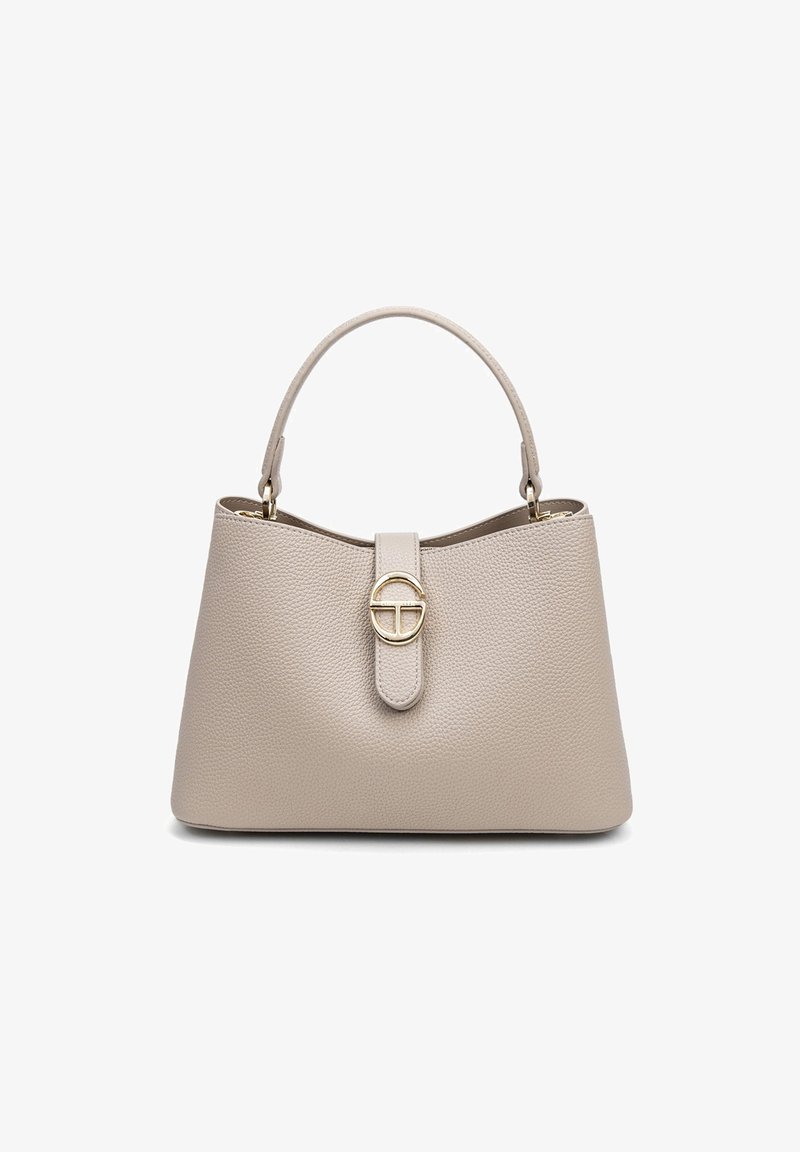 Sac à main en cuir beige avec une finition texturée, une poignée unique et un accent en métal doré circulaire sur une sangle en cuir.