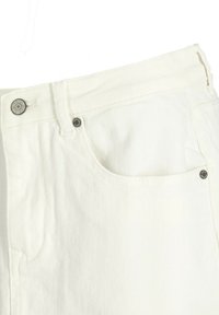 Jean en denim blanc avec une finition texturée, présentant un design traditionnel à cinq poches, des éléments en métal et une fermeture à bouton.