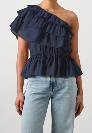 Navy blue, one-shoulder top with layered ruffles, elastic peplum waist, and lightweight fabric; paired with light blue denim jeans.
