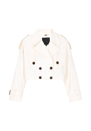Gesneden double-breasted jas in crème, met grote donkere knopen, schouderepauletten en omgeslagen manchetten als accenten.