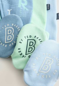 Gaiši zili un piparmētru zaļi zeķes ar drukātiem uzrakstiem un apaļu logotipu ar stilizētu "B". Mīksts audums ar gludu tekstūru.