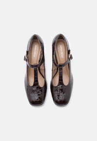 Hnědé lakované kožené T-bar boty s krokodýlí texturou, kulatou špičkou, s přezkou a světlými vínovými stélkami.