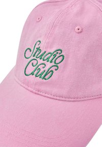 Casquette de baseball en coton rose avec texte brodé vert "Studio Club" sur le panneau avant.