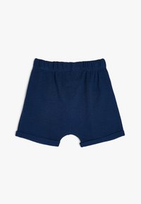 Mørkeblå strikkede shorts med elastisk talje, op rullede ærmer og en rund udsparing i bunden for komfort og bevægelsesfrihed.
