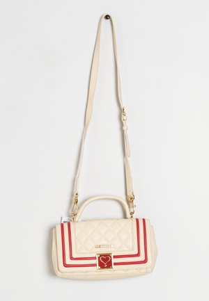 Crèmekleurige gestikte handtas met rode bies, gouden hartvormige sluiting, "Love Moschino"-logo, bovenhandvat en verstelbare schouderriem, hangend aan een witte muur.