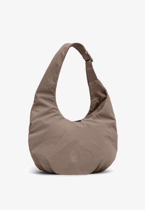 Miękka torebka na ramię w kształcie półksiężyca w kolorze taupe z szerokim paskiem i subtelnym logo „GOT BAG” na środku z przodu.