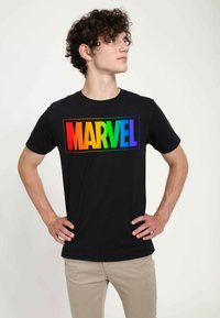 Czarny t-shirt z grafiką "MARVEL" w tęczowym gradiencie w prostokątnym kształcie. Krótkie rękawy, okrągły dekolt i miękki materiał bawełniany.