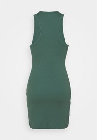 Robe courte moulante sans manches, côtelée, de couleur verte douce, avec un dos nageur et un col rond, vue de dos.