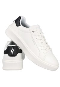 Zapatillas blancas con una superficie de cuero suave, puntera redonda y un talón negro. Cuentan con cordones, una mediasuela texturizada y la marca Skechers en el lateral.