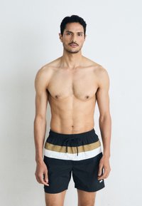 Schwarze Schwimmshorts mit horizontalen Streifen in Weiß und Khaki, aus leichtem Material gefertigt, mit elastischem Bund und Kordelzug.