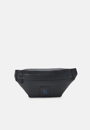 Czarna skórzana saszetka na pas z dwoma zamykanymi na zamek kieszeniami i małą naszywką z logo Calvin Klein Jeans na przednim środku.