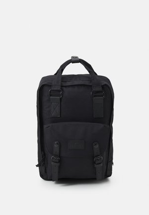Mochila preta feita de tecido durável, com alças superiores duplas, correias ajustáveis e um bolso frontal com detalhes em fivela.