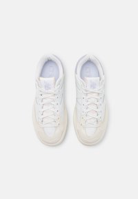 Zapatillas blancas con superposiciones texturizadas, acentos rosas y cordones. Cuentan con un collar acolchado y una suela flexible. Diseño atlético moderno.