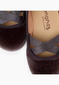 Scarpe da balletto in velluto marrone scuro con punta arrotondata, cinturini in raso incrociati e una fodera interna liscia con stampa del logo.