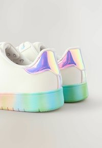 Weiße Sneakers mit irisierenden Akzenten an der Ferse. Die Sohle hat einen Farbverlauf von Blau zu Grün. Glatte Textur, minimalistisches Design.