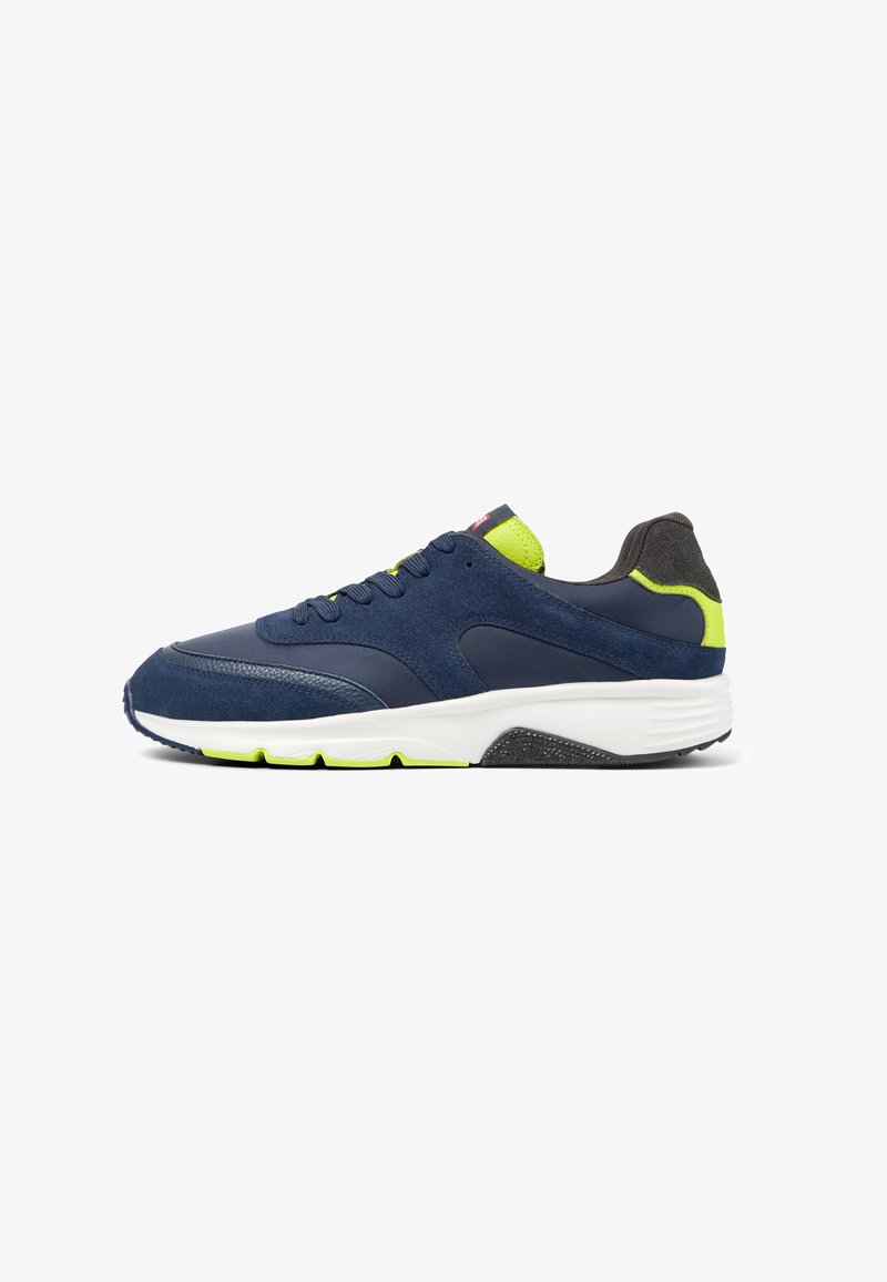 Scarpa sportiva blu navy con accenti verde lime, caratterizzata da una tomaia testurizzata e suola bianca. Vista laterale che mette in evidenza dettagli e design.