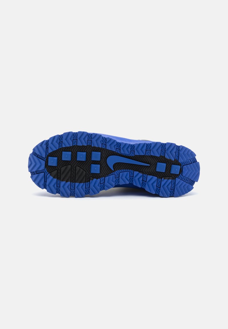 Suela de zapatilla deportiva con un diseño de banda de rodadura robusto en goma azul y negra. Superficie texturizada con detalles en relieve para un mejor agarre.
